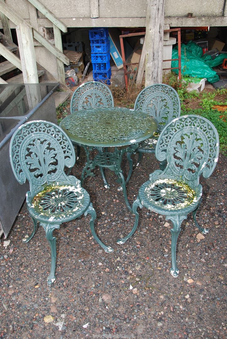 An aluminium patio table (29" diameter x 25 1/2" high) and four chairs.