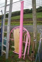 A pink metal single bed with slats.