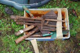 A container of gardening tools; forks, spade, trowel, etc.
