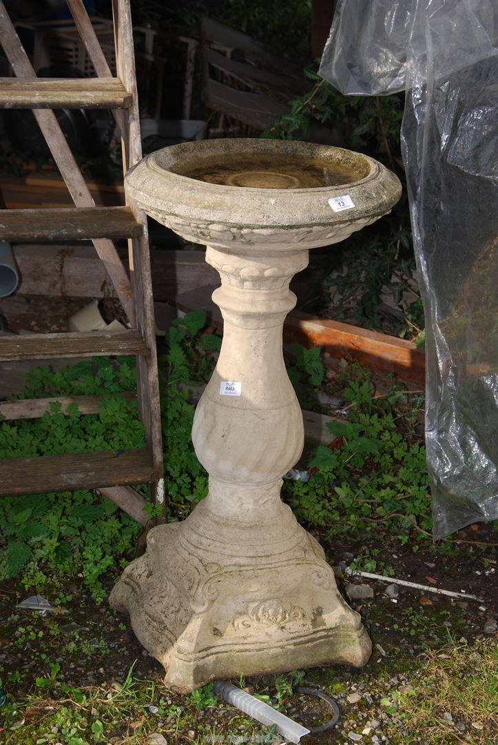 A concrete bird bath, 33" high x 17" diameter.