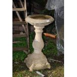 A concrete bird bath, 33" high x 17" diameter.