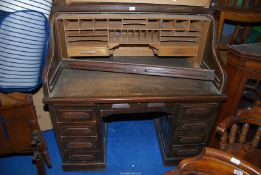 A dark Oak double pedestal roll-top Desk having a frieze drawer over the kneehole and four drawers