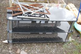A large glass black three tier television stand.