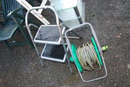 A two step - step ladder, plus a water hose reel.