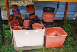 A box of various sized plastic plant pots.