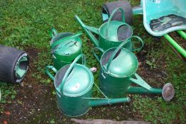 Four painted watering cans.
