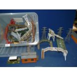 A tub of model railway scenery including fences, platforms, etc.