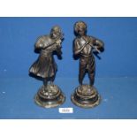 A pair of early 20th century continental bronze figures of a boy and girl playing musical