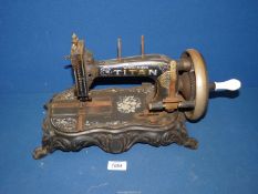 A Victorian sewing Machine on a metal base with sphinx legs, floral and swirl design,