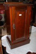 A Walnut/Mahogany Bedside pot Cupboard having a raised and fielded panelled door,