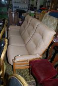 An Ercol three seater Settee with red spotted beige upholstered cushions.
