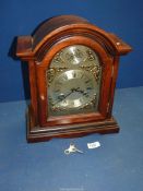 A cased 31 day Clock having domed top, with key, 12'' wide x 14 1/4'' high x 6 1/4'' deep,