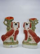 A pair of Staffordshire mantle spaniel spill vases in brown and white with padlocks.