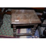 An early rustic peg-joyned two plank topped low Stool standing on turned legs with double bosses