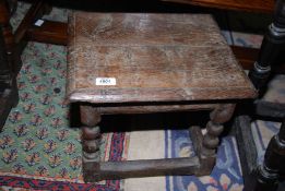 An early rustic peg-joyned two plank topped low Stool standing on turned legs with double bosses