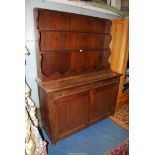 A dark Oak kitchen Dresser, the base with a pair of opposing doors and two frieze drawers,
