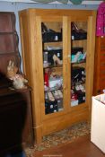 A contemporary light Oak display Cabinet having a pair of opposing glazed doors and a full width