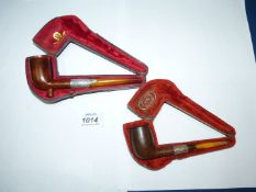 Two antique cased briar Pipes with hallmarked silver mounts and amber stems.