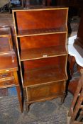 An unusual Mahogany Waterfall three tier Bookshelves having a cupboard below and decorated with