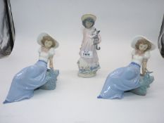 A Lladro girl with a kitten and two Nao figures of a girl with a bird.