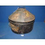 A domed metal hat Box with label fragments, 17" wide x 13" high.