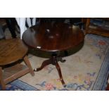 A Mahogany and other woods snap-top circular Table standing on a turned pillar with three elegant