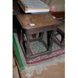 A rustic peg-joyned Oak Joynt Stool standing on sloping turned legs united by perimeter stretchers