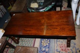 A dark Oak refectory style Coffee Table standing on turned legs united by a substantial "H"