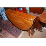 A Mahogany/Satinwood Sutherland table having intricately fretworked end supports and turned legs