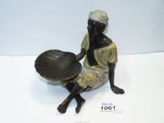 An unusual, cold painted bronze of a man sitting crossed legged