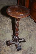 An Oak Jardinere Stand/Lamp Table having a circualr top and a twist column on a cruciform base,
