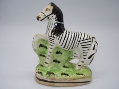 An early Staffordshire flatback of a Zebra, some wear to the base, 6 1/4'' tall.