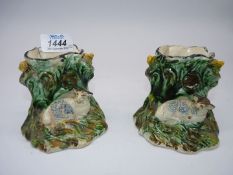 A pair of Staffordshire Spill vases of lambs resting by a tree trunk with a bird either side,