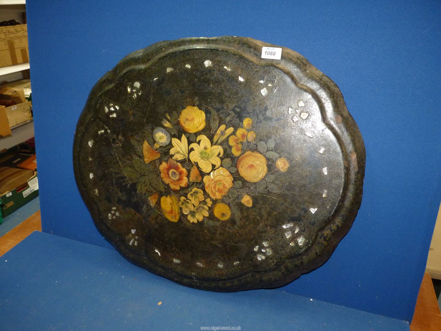 A black papier mache table top with central floral motif, 28" x 22 1/2".