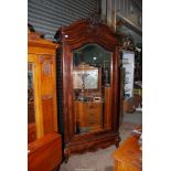 A herringbone grain wood Armoire/Cupboard having a shaped bevelled mirrored door revealing an