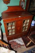 A possibly Edwardian Mahogany Cabinet having a pair of opposing glazed doors flanking a central