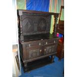 A dark Oak Sideboard having carved details to the doors and up-stand,