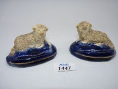 A pair of Staffordshire pottery Sheep on royal blue cushions, circa 1820, chip to one base,