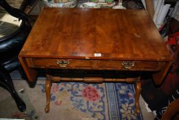 A cross-banded Yewwood finished Sofa Table supported to either end with triple turned uprights,