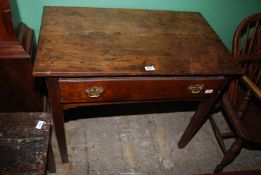 An early 19th century Georgian Oak side Table having a two plank top and standing on tapering