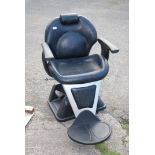 A stylish black upholstered swivel adjustable Beautician's Armchair with headrest adjustable for