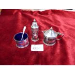 A three piece silver cruet set complete with blue liners,