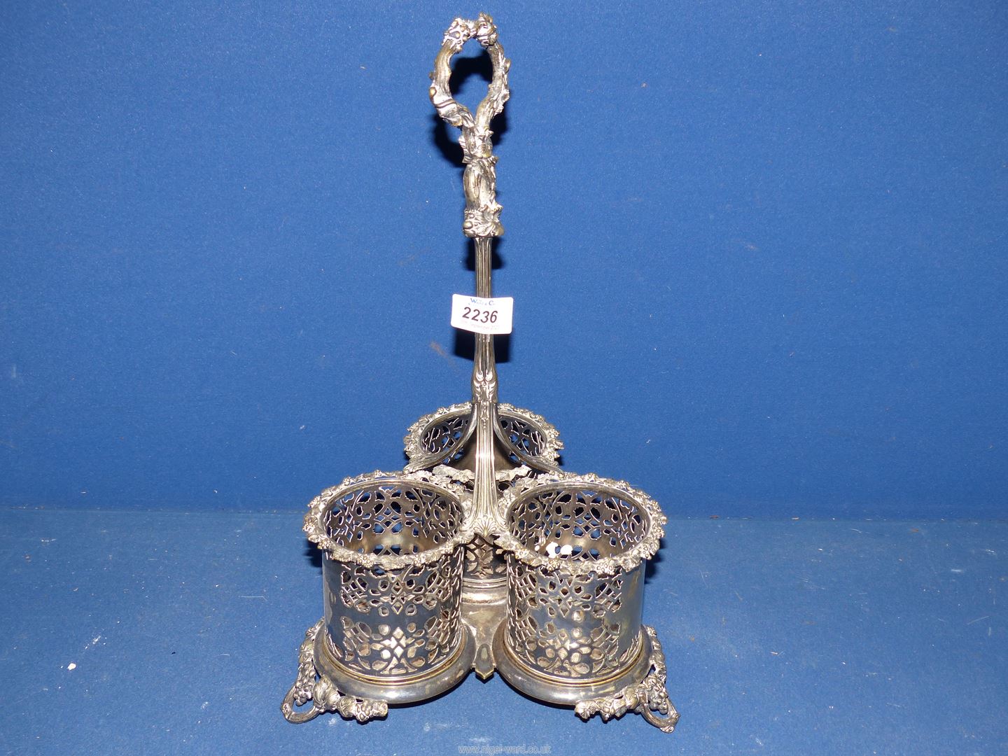 A plated triple bottle Coaster having a tall handle and ornate holders, 16" tall.