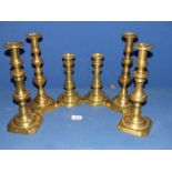 Three pairs of brass candlesticks.