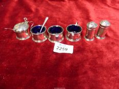 A Silver cruet set with blue glass liners and two spoons, hallmarks for Birmingham 1931 and 1932,