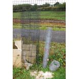 A roll of chicken wire and a roll of barbed wire and a flat pack cage.