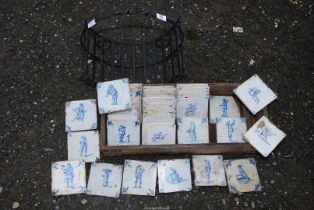 A quantity of blue and white Delft tiles, plus a metal log basket.