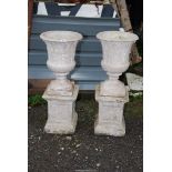 A pair of tall concrete urns standing on square plinth - 15" across x 38½" high.