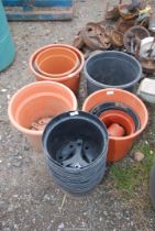 A quantity of black and terracotta planters.