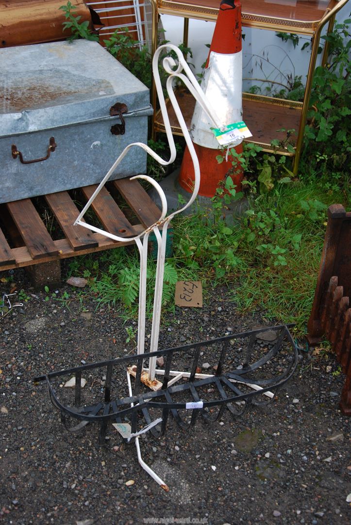 A wall basket and a metal sculpture of a stork.